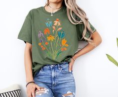 Flower T-Shirt Floral T-Shirt Botanical Shirt Wild Flower Tee Vintage Aesthetic Cottagecore Clothing Nature T-Shirt For Women Gift for Her Embrace the beauty of nature with our stunning Wild Spring Flowers T-shirt! This vibrant t-shirt features a gorgeous print of assorted blue, pink, orange, and purple wildflowers that will brighten up your day. Material: 100% cotton for a soft and comfortable feel, ensuring breathability and durability wash after wash. Features: - Seamless twin needle collar f Purple Wildflowers, Aesthetic Cottagecore, Botanical Shirt, Wild Flower, T Shirt For Women, Vintage Aesthetic, Floral Shirt, Polished Look, Vintage Tees