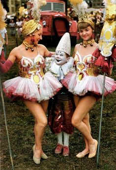 three women in costumes standing next to each other with masks on their heads and legs