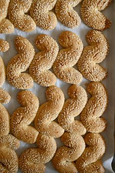 sesame seed bagels are lined up on a baking sheet