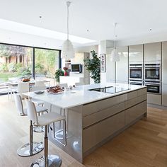 a modern kitchen with stainless steel appliances and white counter tops, along with an island