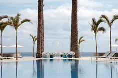 an empty swimming pool surrounded by palm trees