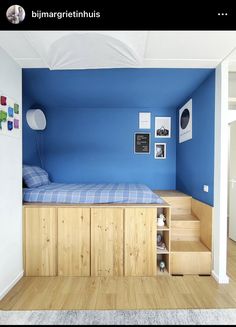 a bedroom with blue walls and wooden floors