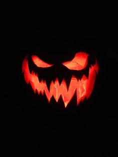 a carved pumpkin with glowing eyes and teeth