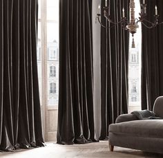 an elegant living room with grey curtains and chandelier