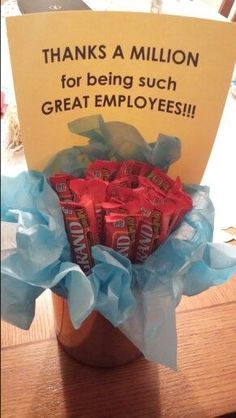 a vase filled with candy bar wrapped in tissue paper