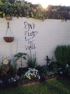 a white brick wall with pink floyd the wall written on it in black spray paint