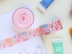 various stationery items are laid out on a white table with pink and blue accents