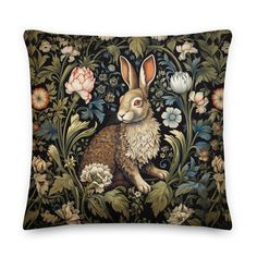 a decorative pillow with an image of a rabbit sitting in the middle of flowers and foliage