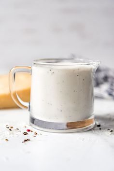 a glass pitcher filled with white liquid next to a rolling pin