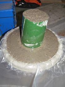 a green bucket sitting on top of a pile of cement