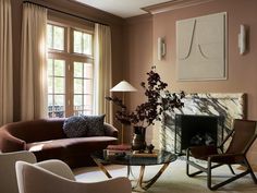 a living room filled with furniture and a fire place in front of a window covered in curtains