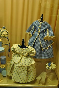 a display case filled with different types of baby clothes and accessories on top of a table