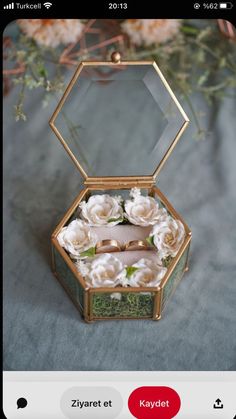 an open jewelry box with flowers inside on a blue tableclothed surface and text that reads, zyrrett et kaydet