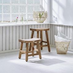 two wooden stools sitting next to each other in a room with white walls and flooring