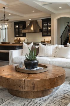 a living room filled with furniture and a wooden table topped with a potted plant