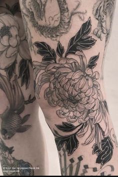 a woman's legs with tattoos and flowers on them