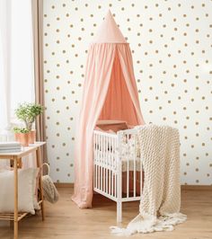 a baby's room with polka dot wallpaper and a crib in the corner