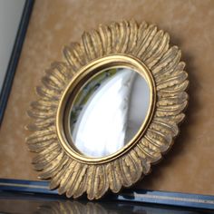 a gold mirror sitting on top of a table