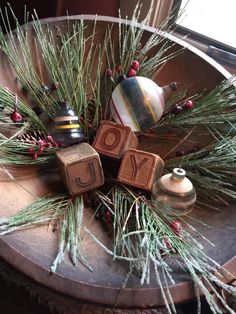 the word joy spelled with wooden blocks surrounded by pine needles and other holiday decor items