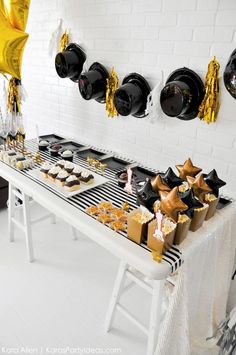 a white table topped with black and gold desserts