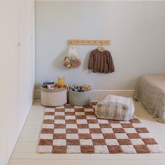 a room with two beds and a checkered rug on the floor