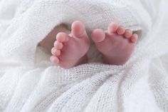 a baby's feet sticking out of a white blanket