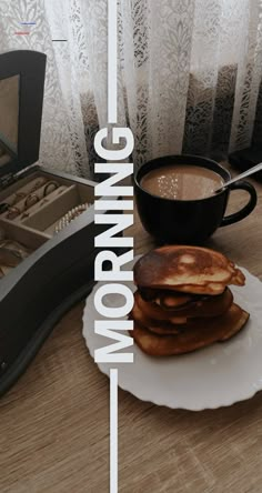 a stack of pancakes sitting on top of a white plate next to a cup of coffee