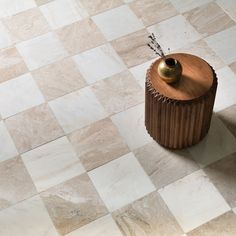 a vase sitting on top of a wooden stand in the middle of a tiled floor