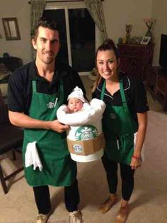 a man and woman holding a baby in a starbucks coffee cup costume while standing next to each other