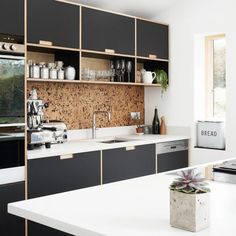 a kitchen with black cabinets and white counter tops