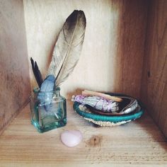 a glass jar with a feather on it next to other items