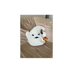 a stuffed animal that is on top of a couch with a carrot in it's mouth