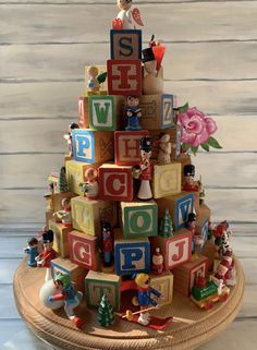 a christmas tree made out of wooden blocks with toys around it and the letters spelled on them