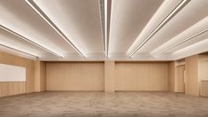 an empty room with wood paneling and lighting