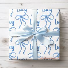 a present wrapped in blue and white paper with a bow