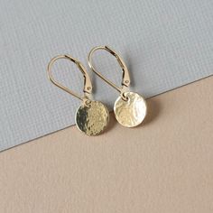 Hammered Small Gold Disc Earrings - Dainty Everyday Round Earrings - Geometric Lever back Earrings These classic gold earrings are perfect for everyday wear. They feature 9.5mm gold-filled discs that have been hammered to create some texture and to give them lots of shine when they catch the light. The lightweight discs dangle from gold-filled lever backs for a minimalistic design that complements any outfit. The earrings are comfortable to wear and their petite size make them a great choice for a jewelry staple. They hang about an inch from the top of the lever backs and they have some subtle movement to them. This timeless accessory will add a pretty golden accent to your look.   You can find more gold earrings here: www.etsy.com/ca/shop/juliegarland/search?search_query=gold+earrings And Minimalist Gold Jewelry, Gold Disc Earrings, Gold Minimalist Jewelry, Gold Jewelry Gift, Jewelry Staples, Gold Disc, Earrings Geometric, Disc Earrings, Earrings Dainty