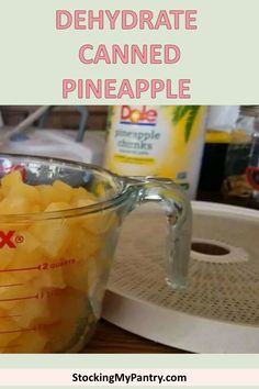 a blender filled with pineapples on top of a wooden table next to a cutting board