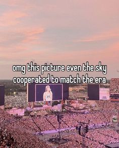 a large crowd is in the middle of a stadium with an image of a woman on it