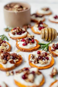 small appetizers with cranberries and nuts are arranged on a table