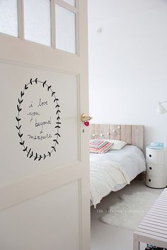 a bedroom with a bed and a white table in it's corner next to the door