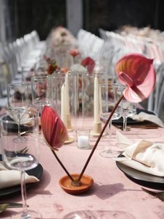 the table is set with wine glasses, plates and napkins for an elegant dinner