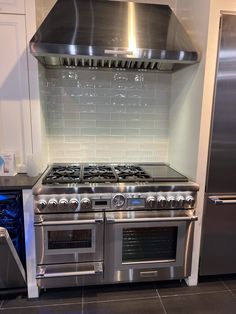 a stainless steel stove and oven in a kitchen with white tile backsplashes