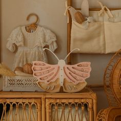 a baby's dress and shoes are sitting on a wicker dresser next to a doll