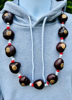 The Classic Buckeye Necklace is a symbol of enduring style that has graced generations of game day enthusiasts. If you've ever cheered on the Buckeyes from the 80s through the early 2000s, this necklace is likely a nostalgic reminder of those unforgettable moments. Recapture the essence of those cherished years with this necklace, crafted with the beloved matte pony bead pattern that's been a staple of Ohio State pride. It's not just an accessory; it's a walk down memory lane, connecting you to How To Make Buckeye Necklaces, Buckeye Necklace Diy, Buckeye Necklaces, Buckeye Wreath, How To Make Buckeyes, Ohio State Buckeyes Crafts, Buckeye Jewelry, Buckeye Crafts, Buckeye Nut