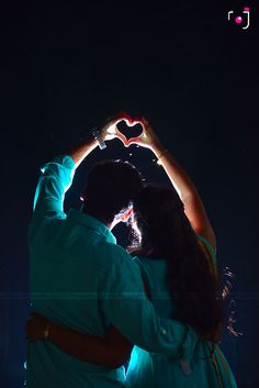 two people making a heart shape with their hands