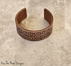 Discover Elegance with the Wide Floral Copper Cuff Embrace timeless beauty and artisanal craftsmanship with our Wide Floral Copper Cuff. Handcrafted using antique rolling plates from the renowned Frank Morrow Cranston Fancy Wire Company, a legacy dating back to 1867, this bracelet is not just an accessory—it's a piece of history. Features You'll Love: Stunning Floral Design: The intricate patterns of flowers, accompanied by scrolled stems and leaf accents, make this cuff a true statement piece. Adjustable Antique Cuff Bracelet With Antique Finish, Adjustable Antique Finish Cuff Bracelet, Bohemian Adjustable Cuff Bracelet With Antique Finish, Adjustable Bohemian Cuff Bracelet With Antique Finish, Formal Adjustable Etched Cuff Bracelet, Traditional Stamped Cuff Bracelet For Formal Wear, Traditional Stamped Cuff Bracelet For Formal Occasions, Antique Finish Adjustable Cuff Bracelet, Elegant Adjustable Cuff Bracelet With Patina