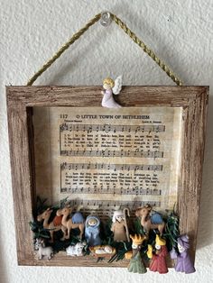 an old sheet music is hung on the wall with some figurines in it