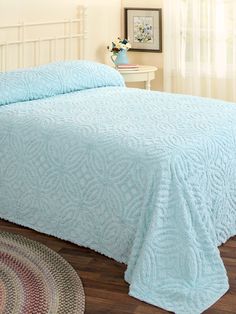 a bed with a blue bedspread on top of it