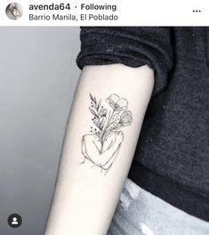 a woman's arm with a flower tattoo on it