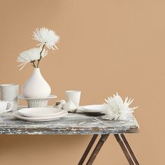 a table topped with white dishes and vases